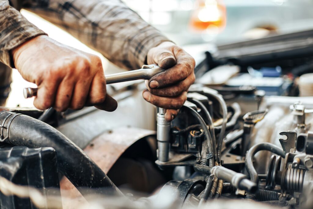 dirty hands of auto mechanic reparing car